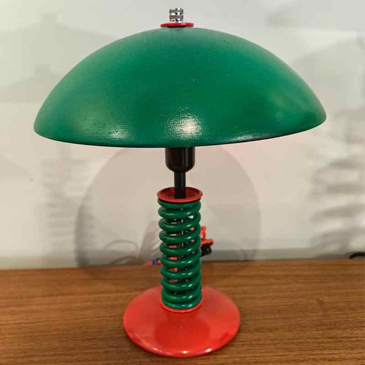 Lámpara verde de muelle con base roja.